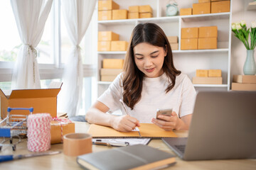 Woman Writing Customer Details for Shipping in Home Office, Packing Box and Writing Customer Information for Efficient Shipping, E-Commerce and Online Selling Concept.