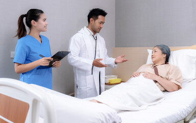 Obraz premium Elderly Asian woman is being treated at a hospital under close supervision of doctors and nurses.