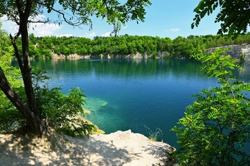 Beautiful flooded quarry with clear water for swimming. Summer landscape concept with nature. Masovice - Czech Republic.