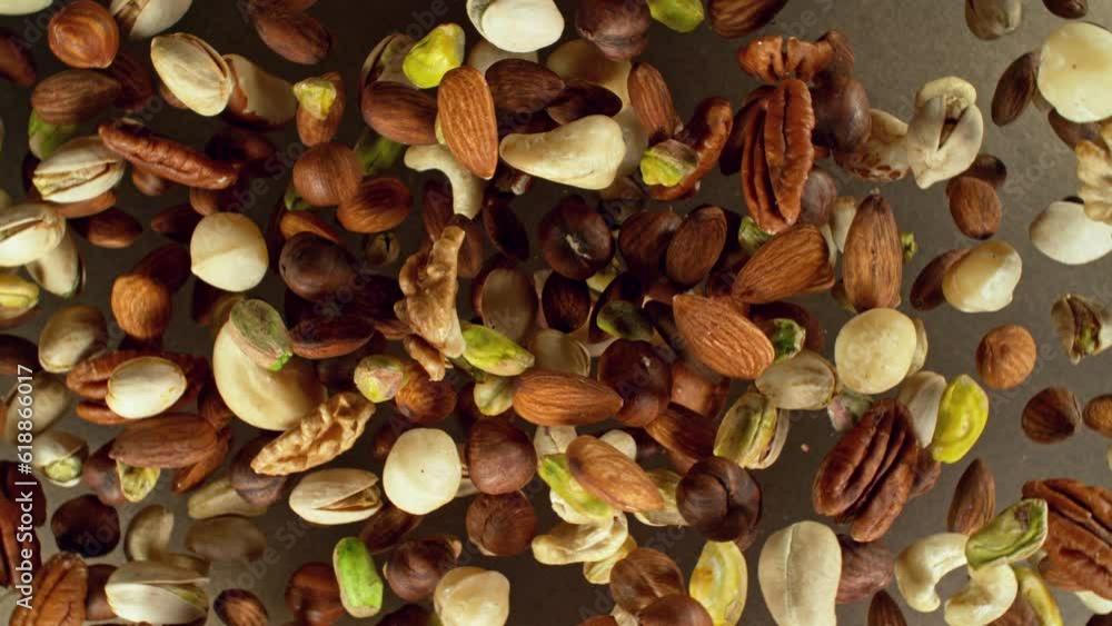 Poster super slow motion of rotating mix nuts up to the air. filmed on high speed cinema camera, 1000fps, p
