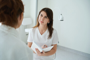 Gynecologist talking with female patient during consultation in hospital