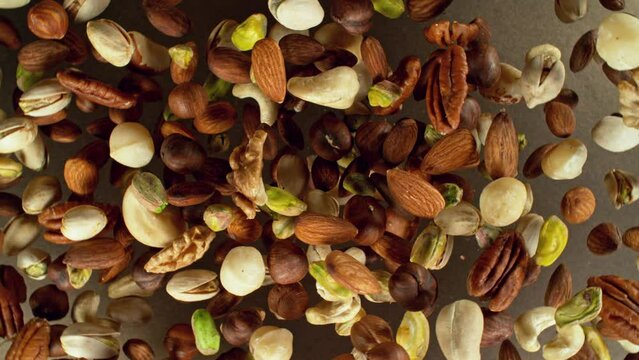 Super slow motion of rotating mix nuts up to the air. Filmed on high speed cinema camera, 1000fps, placed on high speed cine bot. 