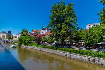 Fototapeta na wymiar A view from the Butchers Bridge along the River Ljubljanica in Ljubljana, Slovenia in summertime