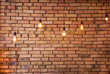Old electric incandescent lamps with tungsten filament. Against the backdrop of a brick wall....