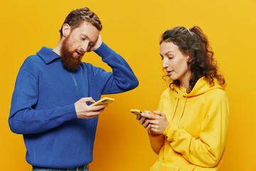Woman man cheerful couple with phones in hand social networking and communication crooked smile fun...