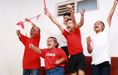 Indonesian kids cheering while watching television to supporting Indonesian team