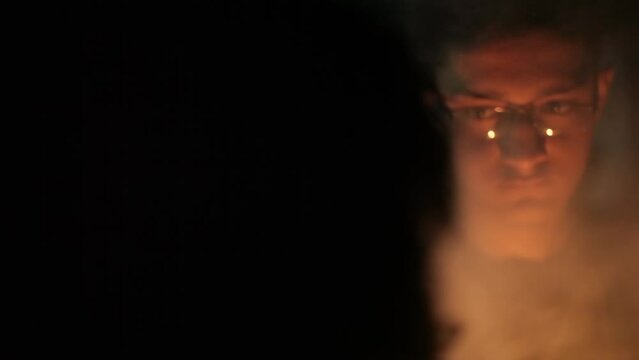 Cinematic shot of a man and a scary person with a mask on face to face, close-up shot with smoke.HD footage 24 FPS. 
