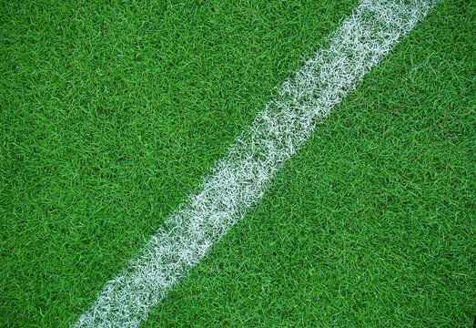 Top view of white stripes made on green grass at sports field. green grass for background or texture