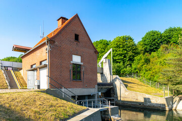 Ancient brick power plant and water mill on the river in countryside