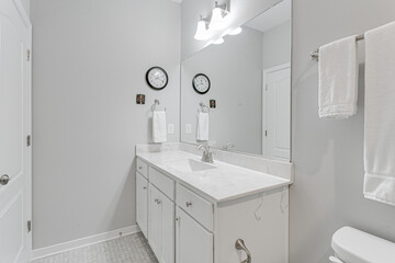 White minimal modern farmhouse residential traditional bathroom with marble countertops and large mirror professionally styled