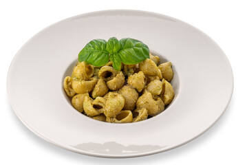 Macaroni pasta with pesto in a white dish with basil leaves, pesto is a typical Genoese sauce of...
