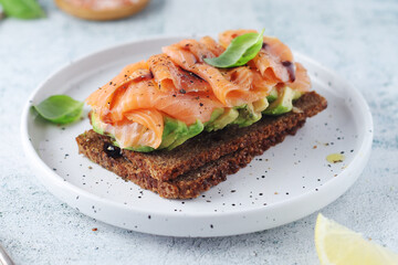 A rye bread sandwich with avocado and salmon	