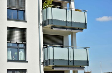 Beton-Balkon mit Edelstahl-Geländer und Glas-Sichtschutz und Sonnendach an der Fassade eines...