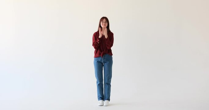 Caucasian teen girl on a white background. She exudes pure satisfaction and delight, applauding with exuberance. Her beaming smile and enthusiastic claps convey her overwhelming happiness.