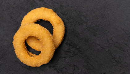 Fried onion rings on black  background