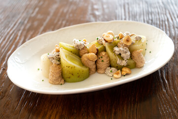 Studio shoto of a bowl of leek salad with a meuniere sauce, gourmet style