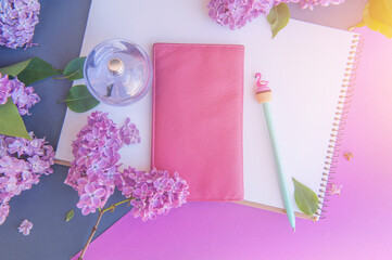 Pen, wallet and perfume bottle with different flowers, flat lay