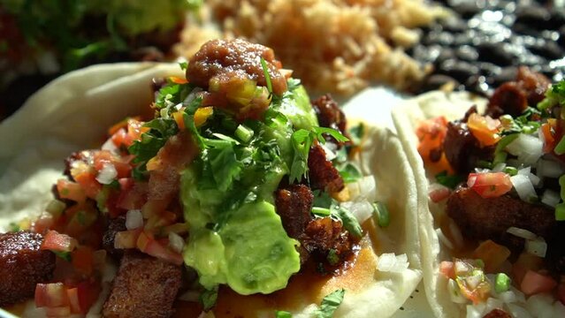 Mexican food Carnitas Taco spicy braised pork with salsa spice and  guacamole avocado topping close up tacoes