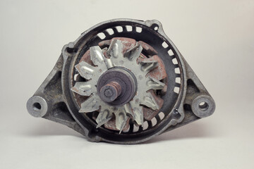 car old alternator details. corroding metal fan on rotor. rusty iron pole pieces. mounting holes in...