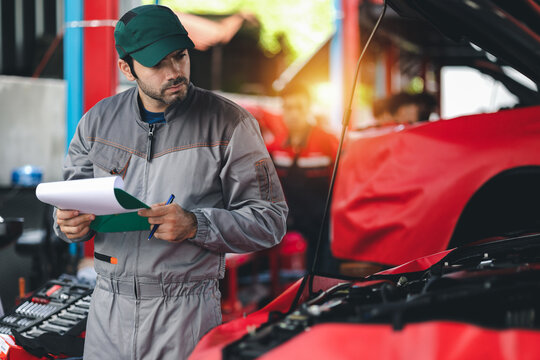 Professional automobile maintenance checking car damage broken part condition with clipboard. Diagnostic and repairing vehicles at garage automotive.