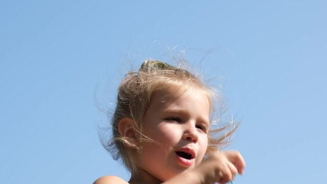 Little girl  blowing soap bubbles . Family lifestyle, outdoors activities, summer holidays with kids. 