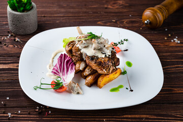 Beef fillet steak with rustic potato wedges, mushrooms, sauce, tomatoes, lettuce and herbs.