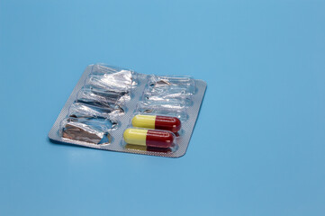 The rest of the antibiotic capsules in a blister pack on a blue background