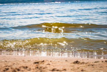 Sparkling silver waves in the sand. Summer beach background with a space for text.