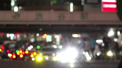 SHIBUYA, TOKYO, JAPAN - JUNE 2023 : View of crowd of people walking around SHIBUYA STATION at night. Busy downtown area in Tokyo. Japanese people, city life and traffic concept video. Time lapse shot.