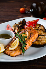 Salmon fillet with eggplant, zucchini, mushrooms, sweet peppers, lemon, rosemary and sauce.