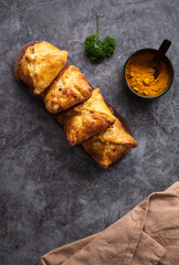 Kazakh and Central Asian cuisine concept. Samsa or samosa or Sambousak on a plate. Samsa or Samosa is an oriental meal to be stuffed with minced meat, cheese or vegetables.