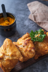 Close up of traditional Kazakh and Central Asian cuisine concept. Samsa or samosa or Sambousak on a plate. Samsa or Samosa is an oriental meal to be stuffed with minced meat, cheese or vegetables.