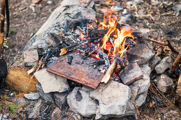Campfire for cooking in the forest. Burning fire. The fire burns in the forest. Burning fire texture. Burning dry branches. Tourist fire in the forest. Texture of burning branches.