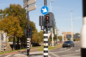 Traffic light-regulated intersection with road signs. Red traffic light