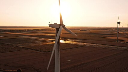 Silhouette of a damaged wind turbine at sunset. Oil seal leaking due to poor maintenance. Investments in renewable green energy