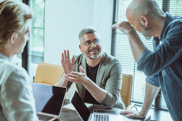 Obraz premium Team of business colleagues in meeting room, attentively discussing and accepting business plan. Atmosphere filled with collaboration and determination as they engage in strategic discussions and