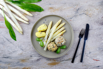 Traditionelle bayrischer weißer Spargel mit Bärlauch- und Mandelbutter serviert als Draufsicht...