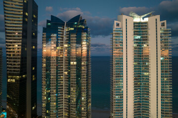 Aerial view of downtown district in Sunny Isles Beach city in Florida, USA. Brightly illuminated...