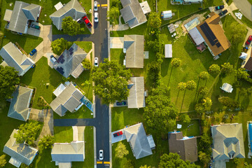 Aerial view of small town America suburban landscape with private homes between green palm trees in...