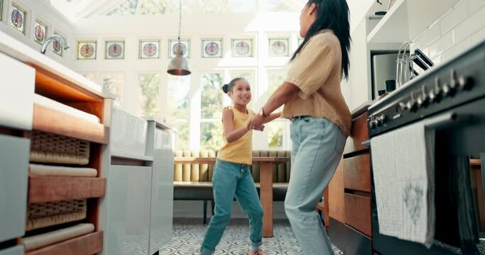 Freedom, kitchen and mom dancing with her daughter for bonding, having fun and spending time together. Happy, goofy and young mother singing and doing dance to music with her girl kid at family home.