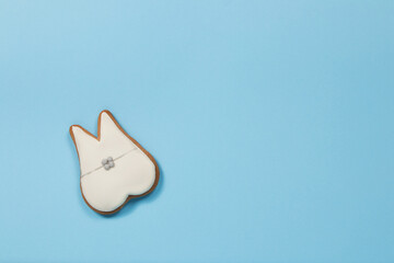 Ginger cookie tooth with braces on blue background 
