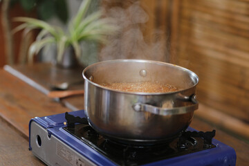 Panela borbulhante preparando o doce tradicional da culinária caiçara de Paraty: o Pé-de-Moleque. Feito com ingredientes autênticos como farinha de mandioca, gengibre ralado e melado de cana.