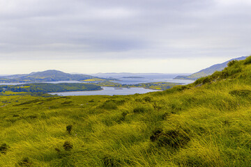 Grass hill overlooking a small village next to an ocean