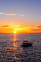 Orange sunset with ocean and a boat