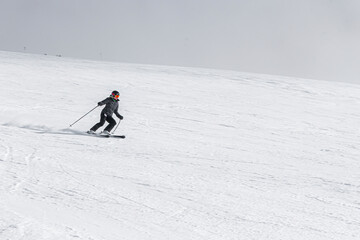 Skier with poles going down a ski slope