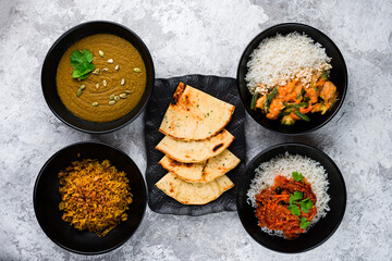 Set of Asian food: rice with stew and vegetables, lentil soup puree and Naan flatbread.