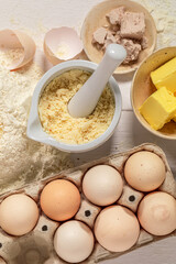 Preparing dough with flour, eggs and butter. Flat lay.