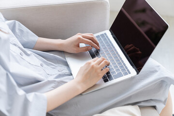 Naklejka premium 部屋でパソコンを見る女性 手元