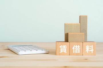 賃借料と書かれたブロック、電卓、ミニチュアの建物