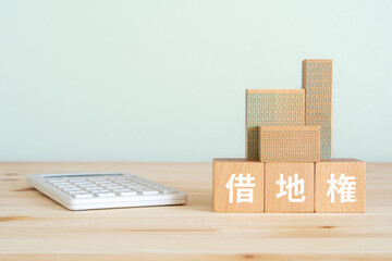 借地権と書かれたブロック、電卓、ミニチュアの建物